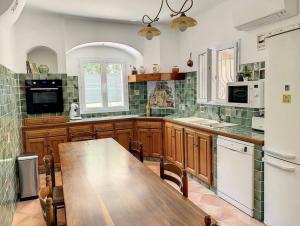 uma cozinha com uma mesa de madeira e uma grande cozinha em Villa sainte maxime golfe de Saint Tropez em Sainte-Maxime