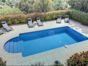 uma piscina com cadeiras e uma piscina em Villa sainte maxime golfe de Saint Tropez em Sainte-Maxime