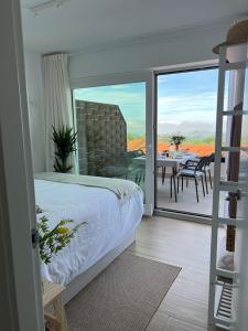 - une chambre avec un lit et un balcon avec une table dans l'établissement Puerta de Comillas - El Mirador de Canales, à Canales