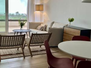 - un salon avec un canapé, une table et des chaises dans l'établissement Puerta de Comillas - El Mirador de Canales, à Canales