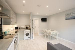 une cuisine avec une table et une salle à manger dans l'établissement Stylish apartment close to Causeway Coast & Glens, à Portglenone