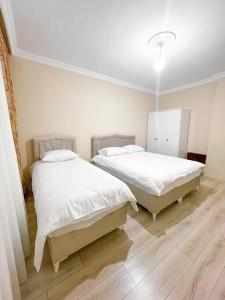 Ce lit se trouve dans un dortoir doté de murs blancs et de parquet. dans l'établissement شقه حديثه 2023 مناسبه للعائلات, à Istanbul