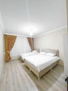 - une chambre blanche avec 2 lits et du parquet dans l'établissement شقه حديثه 2023 مناسبه للعائلات, à Istanbul