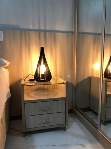 eine Lampe auf einer Kommode in einem Schlafzimmer in der Unterkunft Life Resort - Brasília in Brasilia
