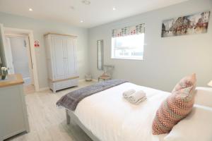 - une chambre avec un lit blanc et 2 serviettes dans l'établissement Stylish apartment close to Causeway Coast & Glens, à Portglenone