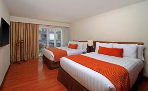 Tempat tidur dalam kamar di Hotel Windsor House Inn By GEH Suites