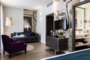 sala de estar con cama, TV y sofá en Hotel Indigo Paris - Opera by IHG, en París