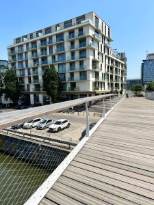 a pier with cars parked in front of a building at Canal View One Bedroom Flat in Brussels