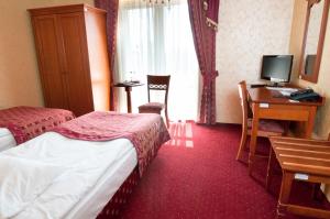 a hotel room with two beds and a desk at Hotel Korona in Sandomierz