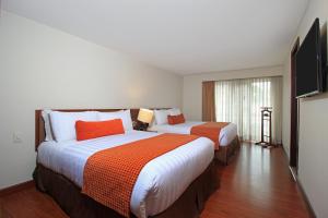Hotel Windsor House Inn By GEH Suites客房内的一张或多张床位