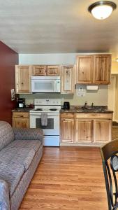 a kitchen with a couch and a stove top oven at Denali Rainbow Village RV Park and Motel in McKinley Park