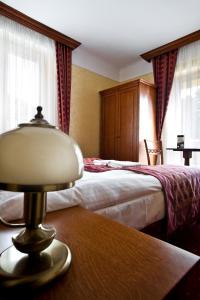 een hotelkamer met 2 bedden en een lamp op een tafel bij Hotel Korona in Sandomierz