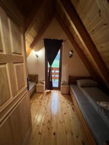 Zimmer im Dachgeschoss mit einem Bett und einem Fenster in der Unterkunft Planinska kuca in Žabljak