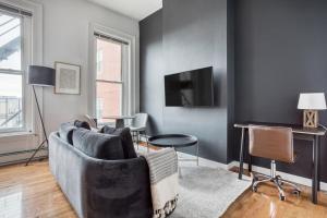 uma sala de estar com um sofá e uma televisão em Well-located S Boston 1BR on E Broadway BOS-473 em Boston