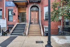 - une porte en bois sur un bâtiment en briques avec des escaliers dans l'établissement Well-located S Boston 1BR on E Broadway BOS-473, à Boston