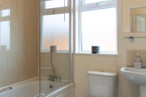 a bathroom with a shower and a toilet and a sink at 56 Meadow View in Woolacombe +17 photos