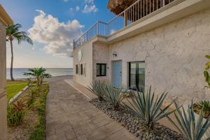 a house on the beach with the ocean in the background at The Queen of Cozumel Beach House -Luxury Beachfront Villa- MILLION DOLLARS VIEW in Cozumel