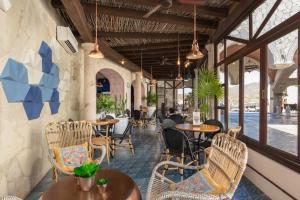 un restaurante con sillas, mesas y ventanas en 3BR Great View Luxury Villa-Cabo San Lucas en El Tule