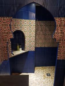 ein blau gefliestes Bad mit einem Spiegel und einem Waschbecken in der Unterkunft Mirador del Olivar in Olvera