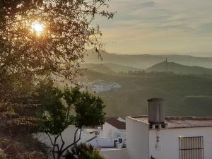 einen Blick auf ein Tal mit der Sonne in der Ferne in der Unterkunft Mirador del Olivar in Olvera