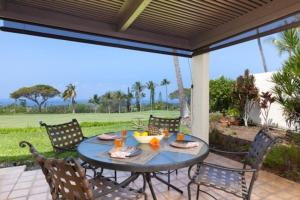 a table and chairs on a patio with a view at Beautiful 2/2 condo in Kailua Kona. Ocean View! in Kailua-Kona