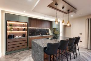 a kitchen with a bar with stools and a counter at Marina West - Amble, Northumberland in Amble