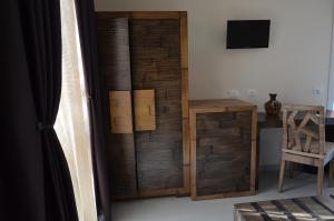 a room with a wooden closet with a desk and a television at B&B Albatros in Castelluzzo