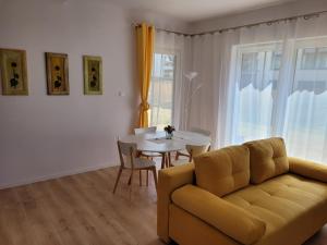 een woonkamer met een bank en een tafel bij Victoria Garden in Tarnowo Podgórne