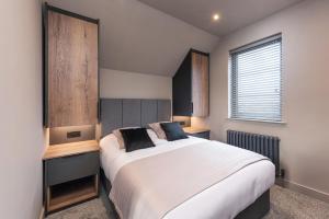 a bedroom with a large white bed and a window at Marina West - Amble, Northumberland in Amble
