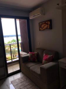 ein Wohnzimmer mit Couch und Balkon in der Unterkunft Life Resort - Brasília in Brasilia