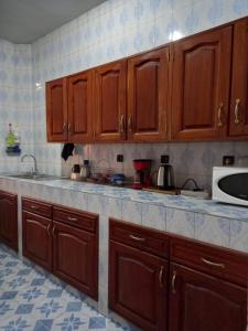 - une cuisine avec des placards en bois et un comptoir dans l'établissement Chambre privée meublée climatisée, à Ziguinchor