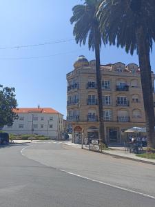 a building with a palm tree next to a street at EL ATICO in Caldas de Reis +19 photos