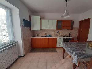 a kitchen with wooden cabinets and a table with a tableablish at La casa di Amelia in Borzonasca