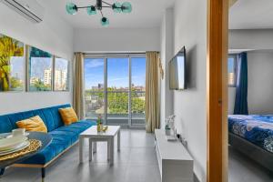 a living room with a blue couch and a bed at Central Suites Tower in Santo Domingo