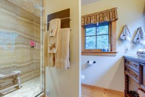 y baño con ducha de cristal y aseo. en Idaho Springs Home with Amazing Mountain Views!, en Idaho Springs