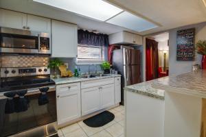 uma cozinha com armários brancos e electrodomésticos de aço inoxidável em Quaint New Orleans Home about 10 Mi to Bourbon St! em Nova Orleães