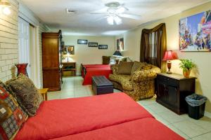 ein Wohnzimmer mit einem roten Sofa und einem Bett in der Unterkunft Quaint New Orleans Home about 10 Mi to Bourbon St! in New Orleans