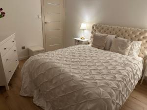 - une chambre avec un grand lit et une couette blanche dans l'établissement Premium Apartament Polna Szczecinek, à Szczecinek