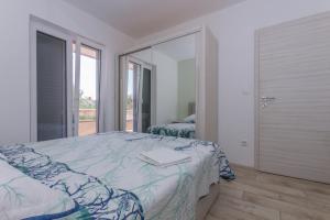 ein Schlafzimmer mit einem Bett und einem großen Spiegel in der Unterkunft Adria Krk Apartment in Krk