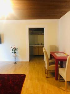 a living room with a table and chairs and a kitchen at Holmes Café & Pension in Engelhartszell