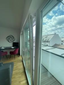 een kamer met een balkon en glazen schuifdeuren bij Swan Stay Property 17 in Wenen