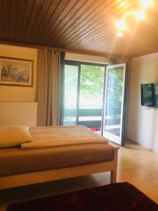 a bedroom with two beds and a large window at Holmes Café & Pension in Engelhartszell