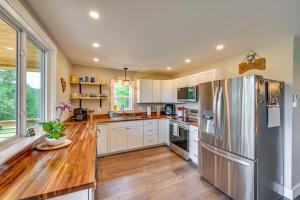 a kitchen with white cabinets and a stainless steel refrigerator at Pickens Cottage about 5 Mi to Table Rock State Park! in Lakemont