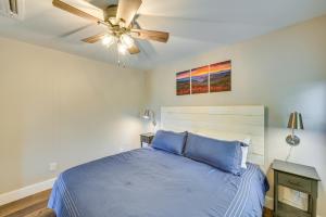 um quarto com uma cama azul e uma ventoinha de tecto em Pickens Cottage about 5 Mi to Table Rock State Park! em Lakemont