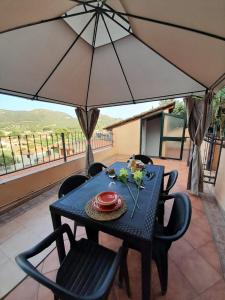 un tavolo blu con sedie e ombrellone su un patio di Casa Frida a Solanas