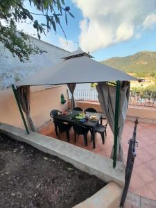 einen Tisch mit einem weißen Regenschirm auf einer Terrasse in der Unterkunft Casa Frida in Solanas