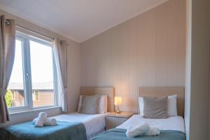 a bedroom with two beds and a teddy bear on the bed at 4 Atlantic Crescent in Woolacombe
