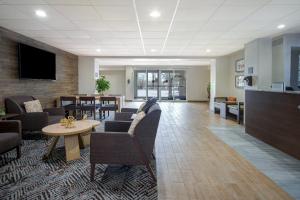 una sala de espera con sofás, mesas y TV en Candlewood Suites Columbia-Fort Jackson, an IHG Hotel, en Columbia