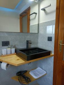 baño con lavabo negro y espejo en Ca' di Aroha en Musignano