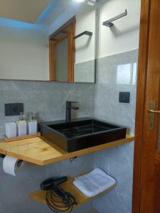 a bathroom with a black sink and a mirror at Ca' di Aroha in Musignano